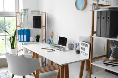 Modern işyeri ve raf üniteleri olan hafif bir ofis.