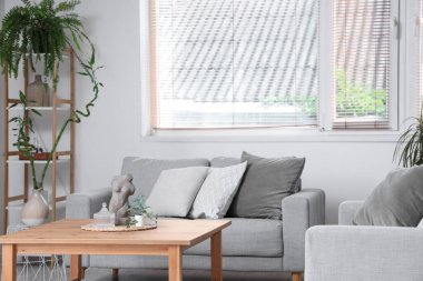 Kanepesi, masası ve çiçekleri olan bir oturma odası.