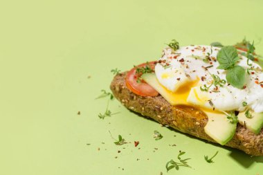 Yeşil arka planda yumurtalı lezzetli sandviç.