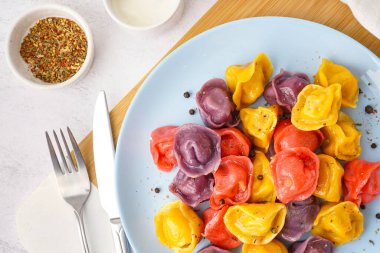 Beyaz arka planda biberli kaynamış renkli hamur köftesi tabağı.