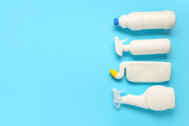 Mavi arka planda temizlik deterjanı şişeleri