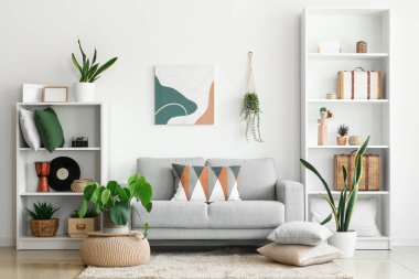 Stylish grey sofa with soft cushions in interior of modern living room