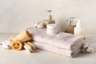 Hafif arkaplanda spa aksesuarları, kozmetik ürünleri ve pamuk çiçekleri olan kompozisyon