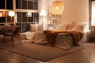 Yatak odasının içi. Yatağında ekose kumaşlar ve geceleri parlayan lambalar var.