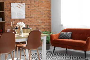 Oturma odası çatı katı tarzında, kanepe, masa ve sandalyeli.