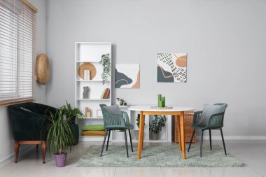 Modern oturma odası, siyah kanepe, masa ve raf ünitesi.