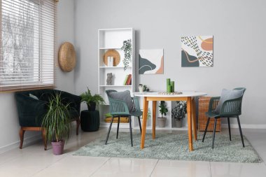 Modern oturma odası, siyah kanepe, masa ve raf ünitesi.