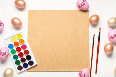 Paskalya yumurtaları ve beyaz arka planda boş kartla güzel bir Paskalya kompozisyonu.