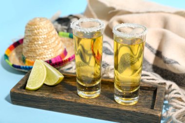 Mavi arka planda tekila ve Meksika şapkası, yakın plan.