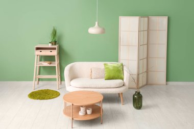 Kanepesi, masası ve katlanır perdesi olan modern oturma odasının şık bir iç mekanı.