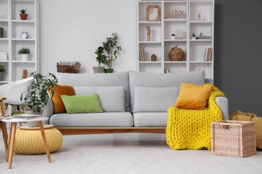 Gri kanepeli ve raf üniteli oturma odasının içi.