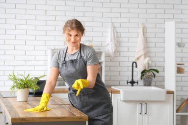 Mutfakta temizlik yapan kadın hademe.