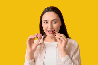 Çikolata kaplı, sarı arka planda çilekli güzel bir kadın.