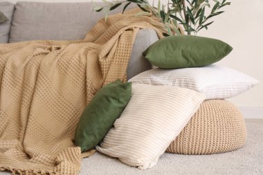 Şık oturma odasında bir yığın yumuşak yastık ve gri kanepe.