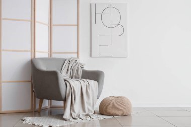 Oturma odasının içi, rahat gri koltuklu, boyalı ve katlanmış ekranlı.