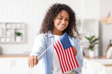 Memleketinde Amerikan bayrağı olan mutlu Afro-Amerikan kadın.
