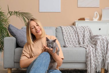 Evde kedisi olan orta yaşlı bir kadın.