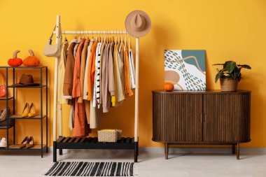 Giysileri, rafları ve çekmeceleri soyunma odasına dizin.