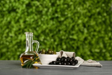 Açık havada gri ahşap masada taze zeytinyağı.