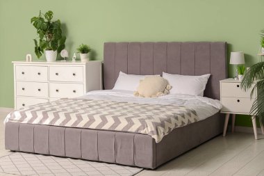 Yatağı ve çekmeceleri olan modern, rahat yatak odasının içi.