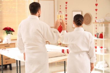 Sevgililer Günü 'nde kaplıca salonunda şampanya içen genç bir çift.