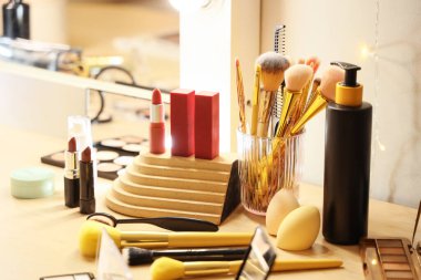 Odada farklı makyaj ürünleri ve fırçalar var.