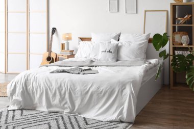 Yataklı, gitarlı ve katlanır perdeli bir gencin odası.