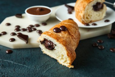 Koyu arkaplanda çikolatalı kruvasan kes.