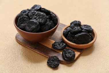 Kase ve ahşap tahta. Bej arka planda kuru erik var.