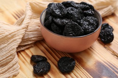 Ahşap arka planda kuru erikli kase