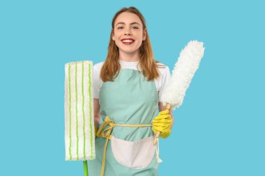 Mavi arka planda paspas ve pp-toz bezi olan güzel bir kadın.