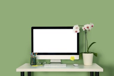 Ofisinde ev bitkisi, kırtasiye ve modern bilgisayarı olan şık bir iş yeri.