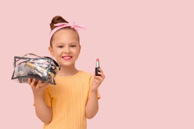 Kozmetik çantası ve pembe arka planda ruju olan sevimli küçük bir kız.