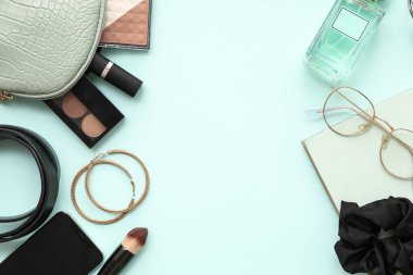 Renkli arka planda kadın aksesuarları, kozmetik ürünleri ve cep telefonu kompozisyonu