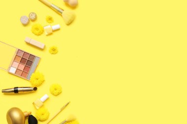 Parfüm şişesi, makyaj malzemeleri, oje ve sarı arka planda çiçekler olan kompozisyon