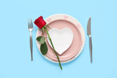 Mavi arka planda kırmızı gül olan güzel bir masa. Sevgililer Günü kutlaması