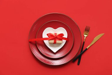 Kırmızı arka planda hediye kutusu olan güzel bir masa. Sevgililer Günü kutlaması