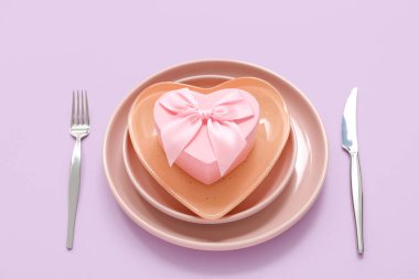 Leylak arka planında hediye kutusu olan güzel bir masa. Sevgililer Günü kutlaması