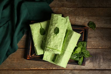 Tahtada taze lavaş ve ahşap zemin üzerinde ıspanak var.