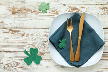 Beautiful table setting for St. Patrick's Day celebration on light wooden background
