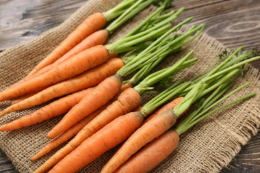 Tahta arka planda bir sürü taze havuç, yakın plan.