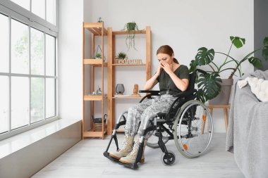 Evde travma sonrası stres bozukluğu olan tekerlekli sandalyedeki kadın asker.