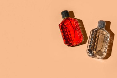 Turuncu arka planda zarif parfüm şişeleri