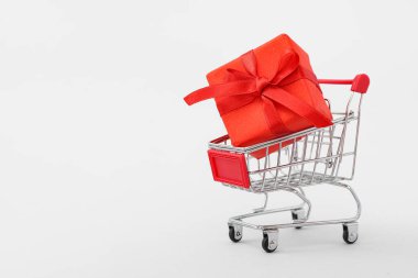 Beyaz arka planda hediye kutusu olan küçük bir alışveriş arabası. Sevgililer Günü kutlaması