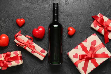 Bir şişe şarap, hediyeler ve siyah grunge arka planda kalp dekoru. Sevgililer Günü kutlaması