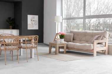 Modern oturma odasının içinde kanepe ve yemek masası var.