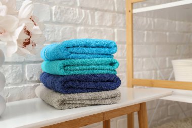 Beyaz masaya temiz yumuşak havlular yığını, yakın plan.