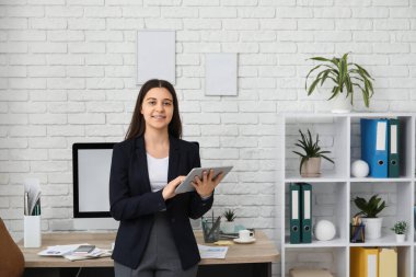 İş yerinin yakınındaki iş yerinde tablet kullanan kadın ofis çalışanı
