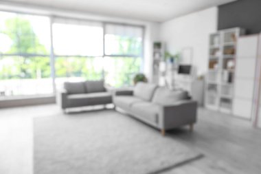 Gri koltukları ve işyeri olan oturma odasının bulanık görüntüsü