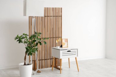 İçinde sehpa, saksı, lamba ve katlanan ekran olan odanın içi.